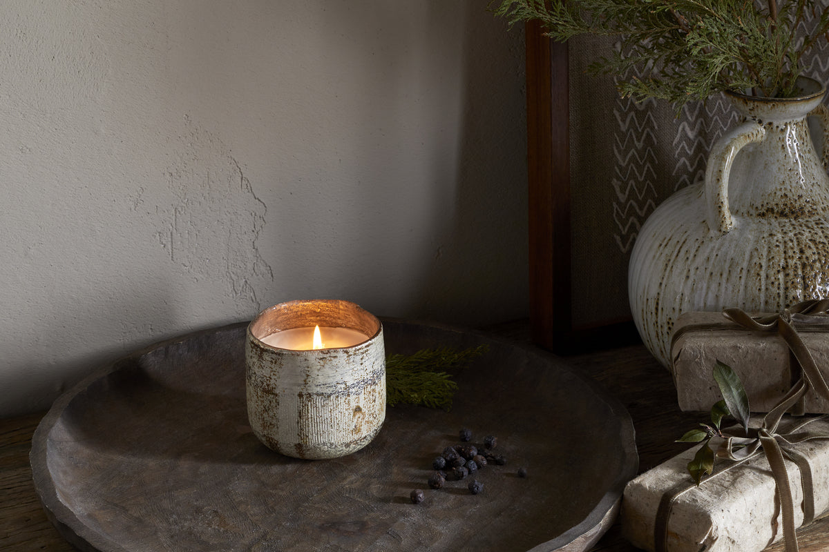 The nkuku Juniper & Fir 1 Wick Scented Candle comes in a reusable vessel, ideal for adding a unique fragrance to any space.
