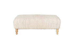 The nkuku Sanja Stripe Upholstered Ottoman in Off White features vertical black stripes on natural linen, four short turned wooden legs with a natural finish, and is showcased against a plain white backdrop for modern appeal.