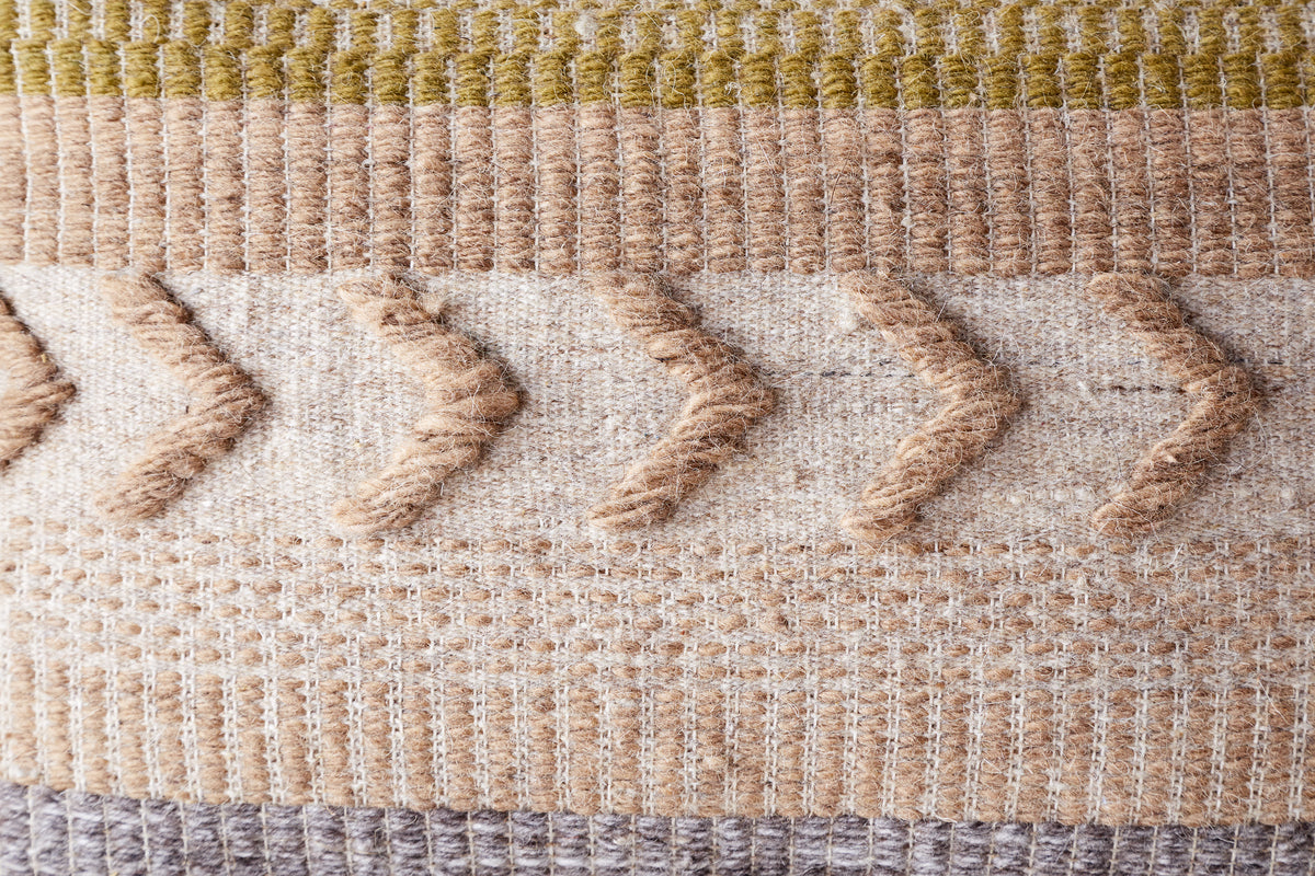 The Tuleeka Wool Cushion Cover - Ochre by nkuku features a textured woven design with beige, cream, brown, ochre, and olive stripes plus raised zigzag lines—ideal for adding stylish flair to any setting.