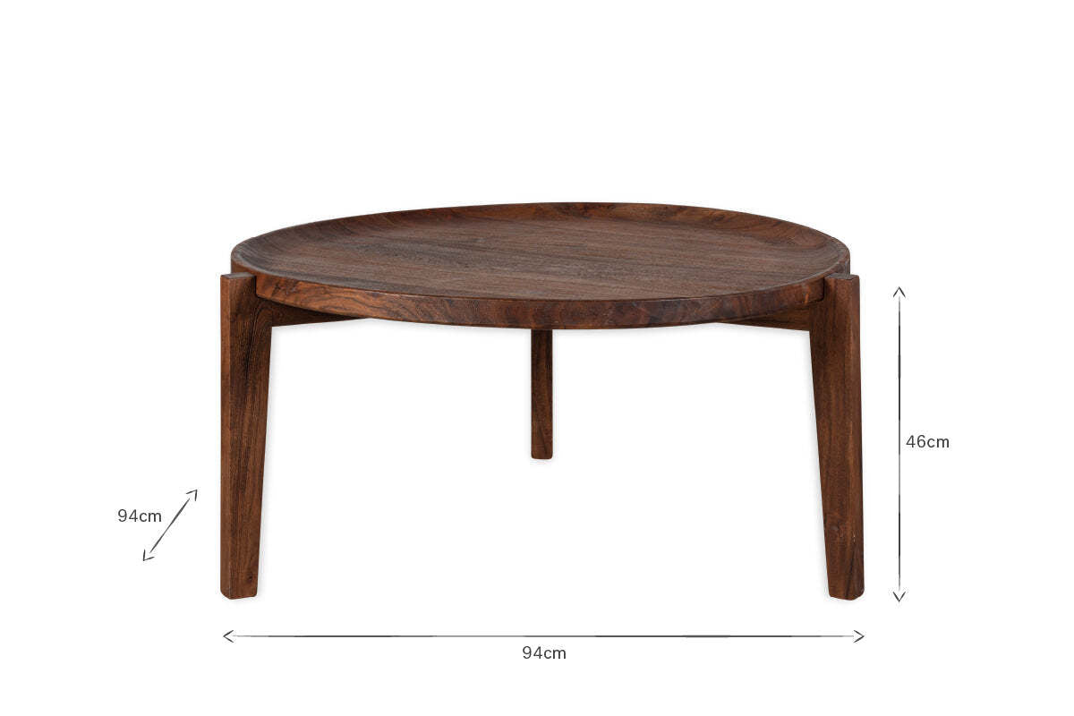 The Umar Mango Wood Coffee Table by nkuku features a sculptural round design with three legs, a curved edge, and a dark brown finish. Measuring 94cm wide by 46cm tall, it stands out beautifully against a plain white background.
