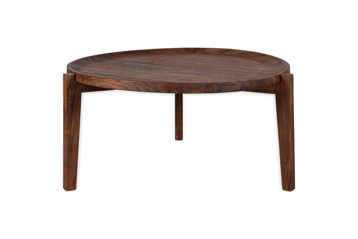 The nkuku Umar Mango Wood Coffee Table in dark brown features a circular design with a raised edge and three sturdy legs. Its modern, sculptural style and clean lines stand out against a plain white background.