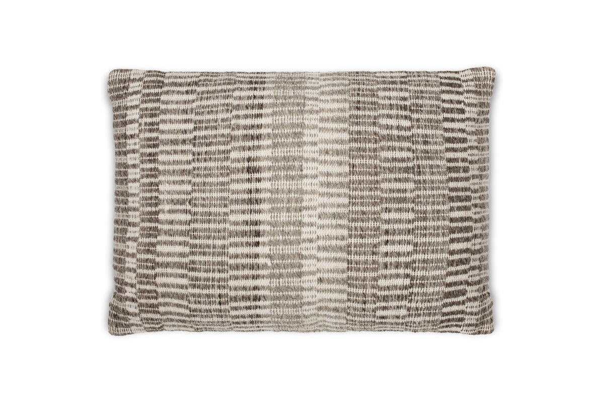 The nkuku Aahna Wool Cushion Cover in Charcoal features a textured, woven design with vertical stripes and a subtle geometric pattern, crafted from wool and recycled polyester. The background is plain white.