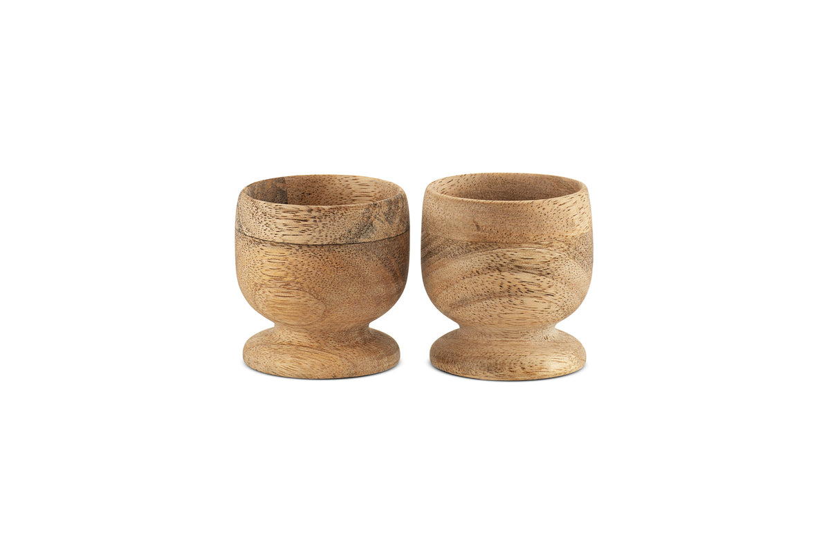 The nkuku Awa Wooden Egg Cup - Natural (Set of 2) features small, round wooden cups with a natural grain finish, perfect for adding classic style and warmth to your breakfast table.