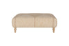The Aranya Upholstered Ottoman - Natural by nkuku features beige cotton jute upholstery with subtle vertical stripes and four light wood legs, making it a perfect living room accent. Shown against a plain white background.