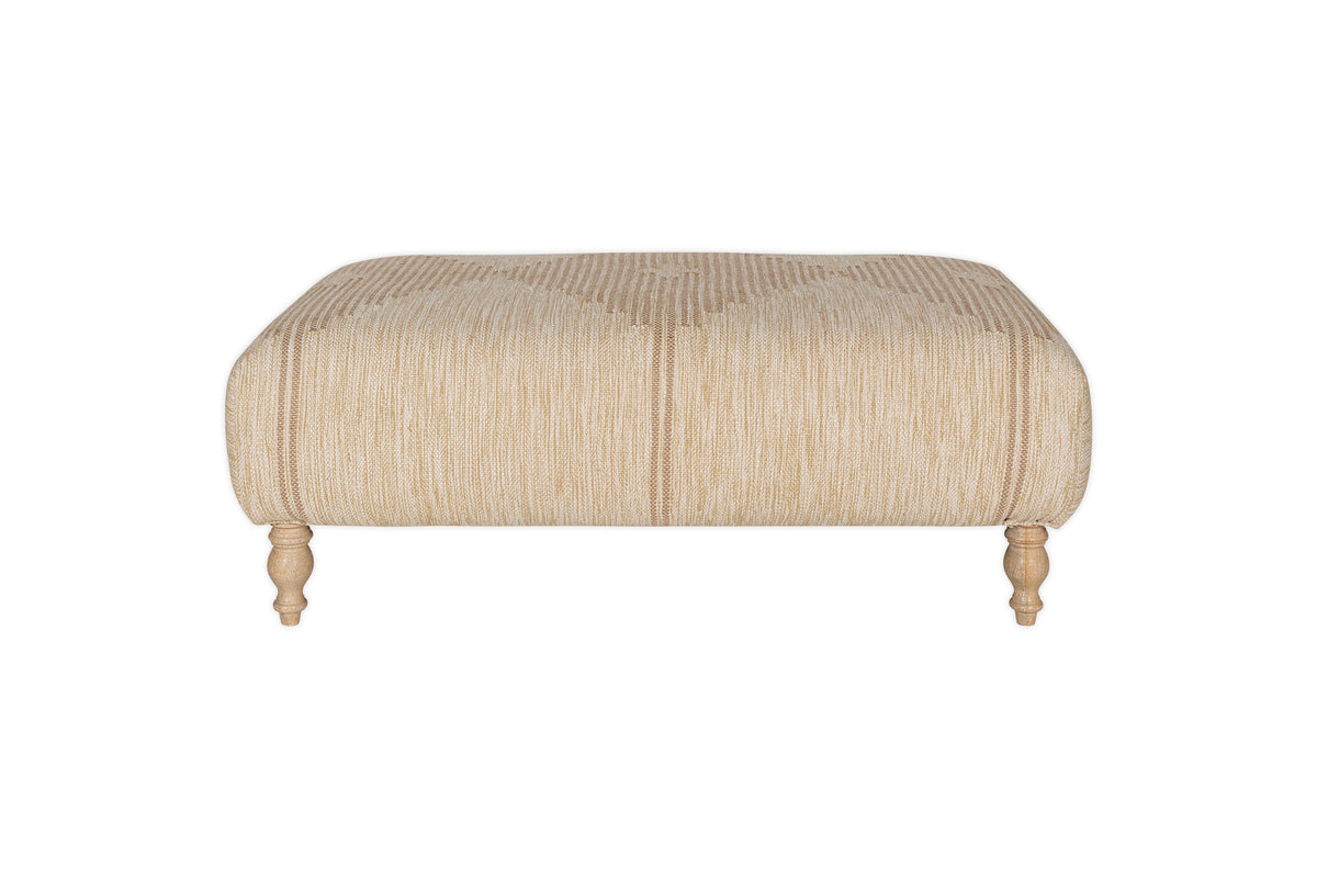 The Aranya Upholstered Ottoman - Natural by nkuku features beige cotton jute upholstery with subtle vertical stripes and four light wood legs, making it a perfect living room accent. Shown against a plain white background.