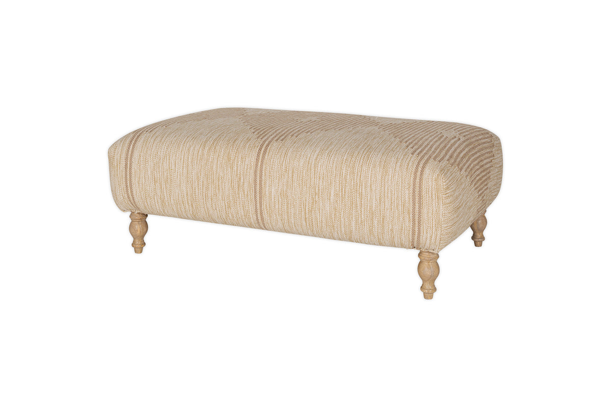 The Aranya Upholstered Ottoman by nkuku features a natural beige cotton-jute blend with subtle stripes and wooden turned legs—an ideal living room accent, pictured against a white background.
