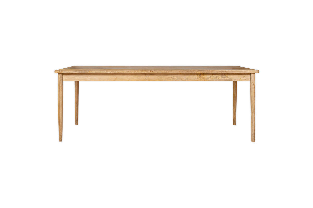 The nkuku Anbu Mango Dining Table - Natural is a rectangular mango wood table with four straight legs and a light natural finish, shown against a plain white background.