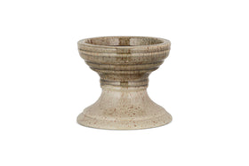 The Cabra Reactive Glaze Candle Holder by nkuku features a wide bowl, ribbed detail, and flared base. Its olive and natural reactive glaze offers a rustic look. The candle holder is centered on a plain white background.