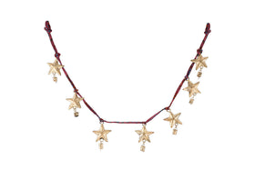 The Didi Star Garland - Antique Brass by nkuku features seven handcrafted brass stars with gold charms on a dark red cord, combining rustic and celestial details for a festive, Christmas-inspired look.
