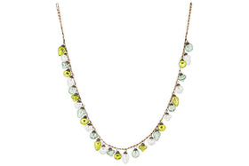 The nkuku Ekiti Bauble Garland - Mixed Green & Clear features a delicate brown chain with evenly spaced recycled glass beads in teardrop shapes of green, white, and yellow, forming a playful U-shape necklace.