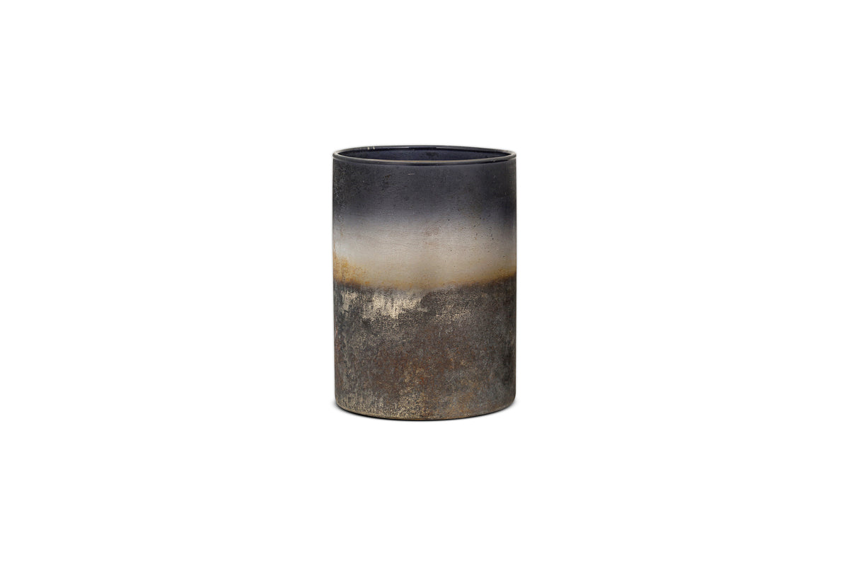 The Etti Tealight Holders by nkuku feature a cylindrical ceramic design in navy and smoke tones, with a matte, rustic gradient finish that evokes an ambient glow against a white background.