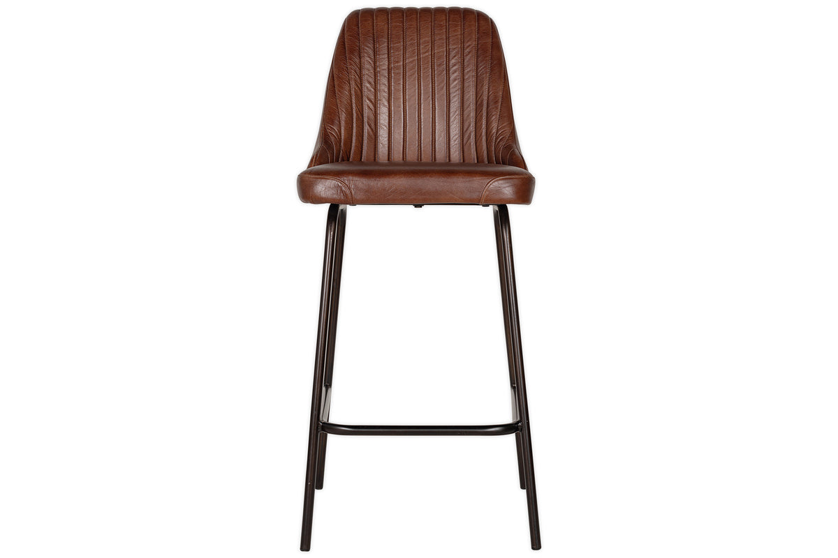 The Harsha Leather Counter Chair by nkuku in chocolate brown features a ribbed, cushioned backrest and seat, with slim black metal legs and a footrest. Shown from the front against a white background; ideal for stylish kitchen island seating.