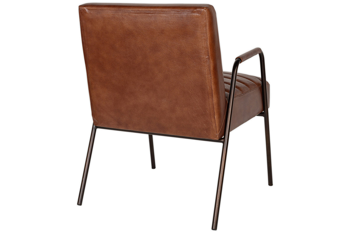 The nkuku Hadithi Leather Occasional Chair in chocolate brown features padded, ribbed buffalo leather on the backrest and seat, slim black metal legs, and armrests. Shown from behind.