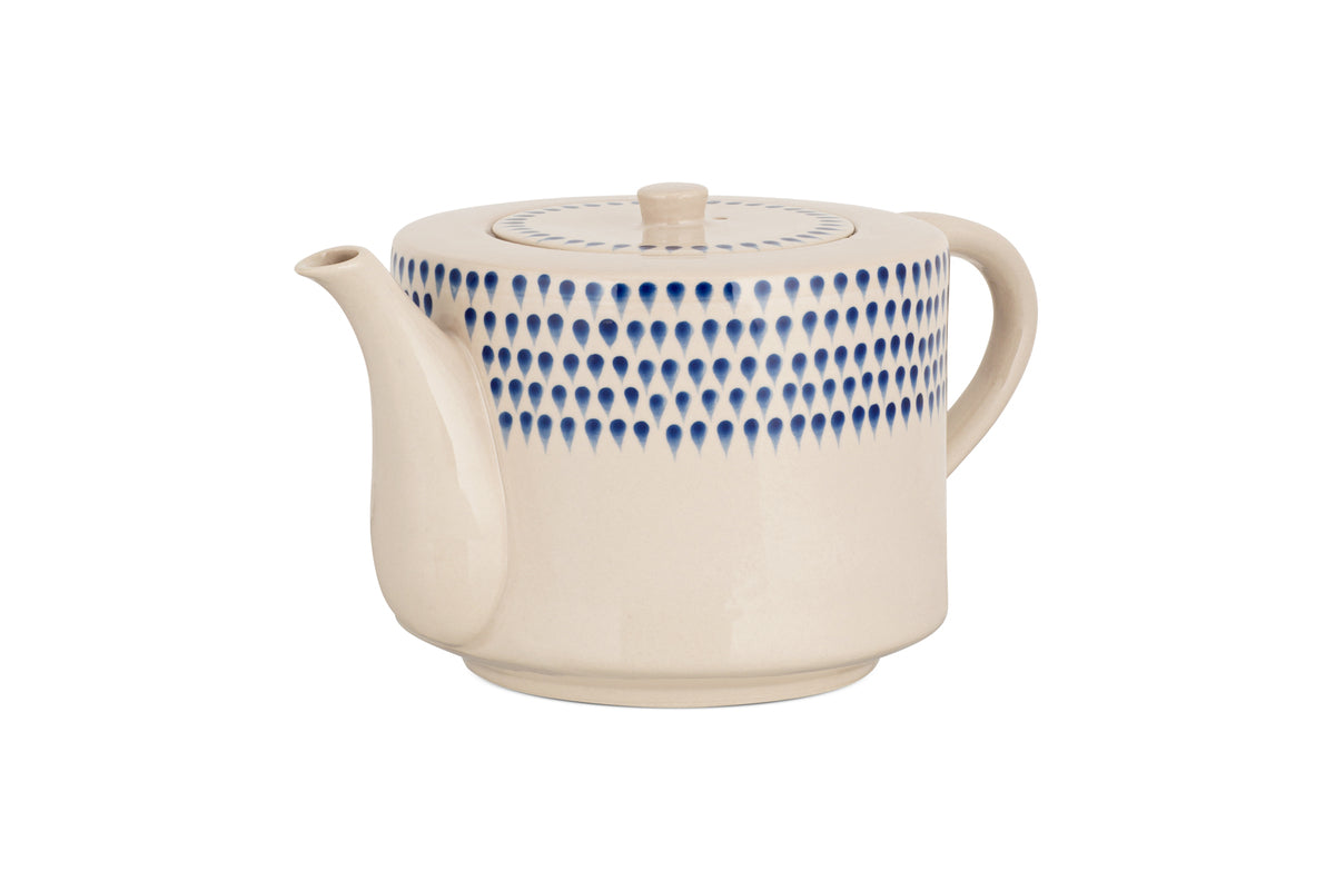 The nkuku Indigo Drop 4 Person Teapot - Cream & Indigo features a cream ceramic finish, curved spout and handle, and hand-painted blue teardrop design—combining modern style with function, its perfect for gifting to tea lovers.