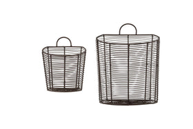 The nkuku Inkollu Wall Hung Baskets in aged brass are shown side by side against a white background, with the smaller basket to the left of the larger one. Each features a handle at the top, ideal for pantry storage. Set includes two baskets.