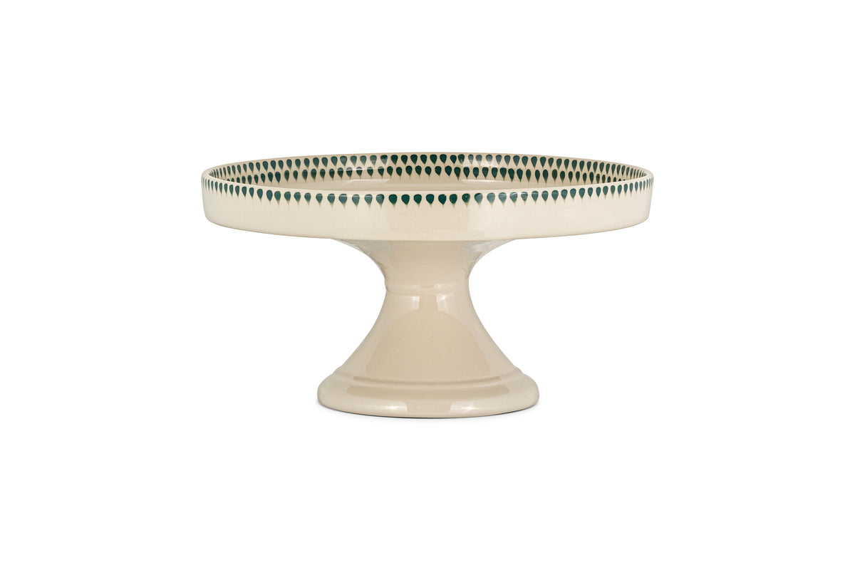 The nkuku Juniper Drop Ceramic Stand in Cream & Juniper features a wide base, round top, and a decorative green drop edge from the Juniper Drop collection.