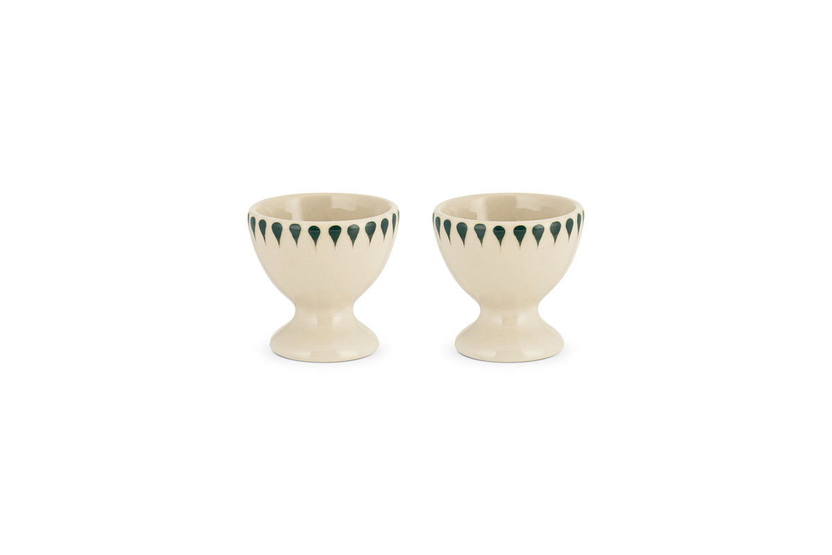 The nkuku Juniper Drop Egg Cups in cream & juniper (set of 2) feature a green drop design around the rim—perfect for brightening up your breakfast table.