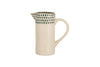 The Juniper Drop Jug - Cream & Juniper - Small by nkuku features a cream ceramic body, curved handle, and narrow spout. Its upper rim is adorned with dark green teardrop patterns—ideal for contemporary tableware collections.