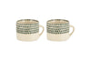 The nkuku Juniper Drop Mug - Cream & Juniper - Large (Set of 2) features two cream ceramic mugs with distinctive handles and a dark juniper green drop design near the rim, shown side by side on a white background.