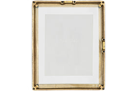 The Jahala Wall Hung Photo Frame by nkuku features a rectangular antique brass frame with decorative ridges and black screws at the corners and sides, and includes a white mat. Shown empty against a white background.
