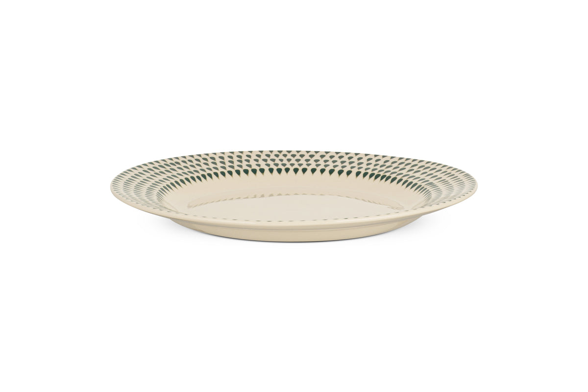 The Juniper Drop Dinner Plate - Cream & Juniper by nkuku features a round, cream ceramic design with a blue geometric rim, showcasing modern tableware style against a white background.