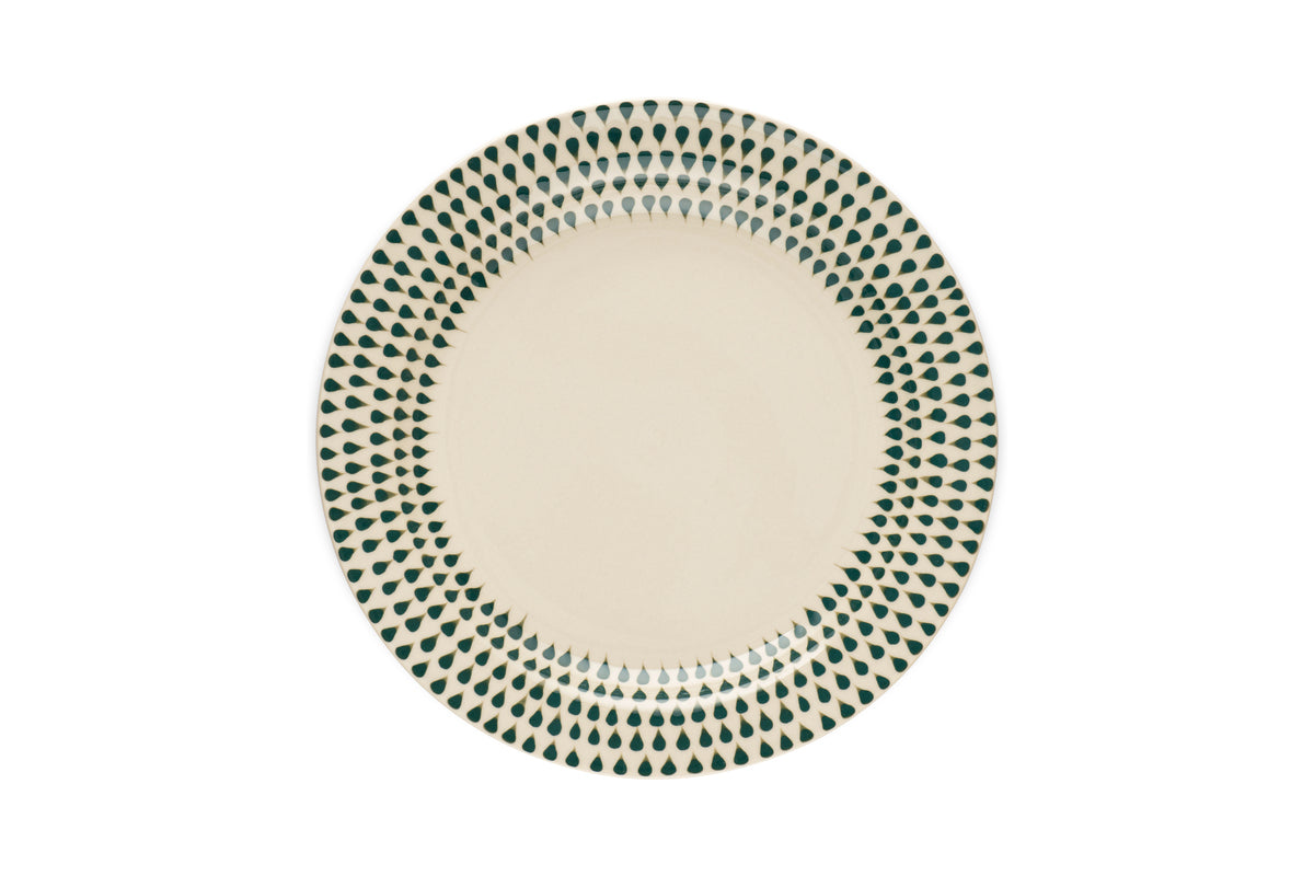 The nkuku Juniper Drop Dinnerware Set in cream and juniper features round ceramic plates with a cream center and a border of green teardrop patterns—perfect for stylish dining.