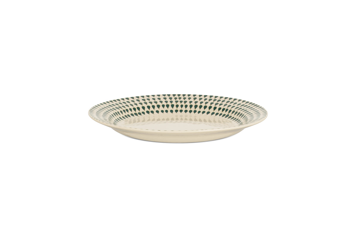 The nkuku Juniper Drop Side Plate in Cream & Juniper features a shallow, round ceramic design with a cream base and evenly spaced dark green dots around the rim, shown on a plain white background.