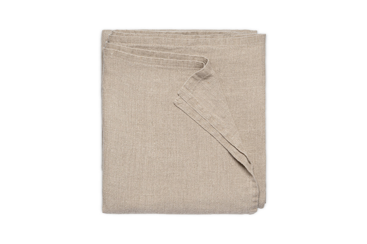 The nkuku Junto Linen Tablecloth in Natural (Small) is neatly folded and displayed against a plain white background.