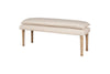 The Kiana Cotton Upholstered Bench - Natural by nkuku features a cushioned beige seat and four light wood legs, offering a simple yet elegant design that serves as a perfect accent piece against a plain white background.
