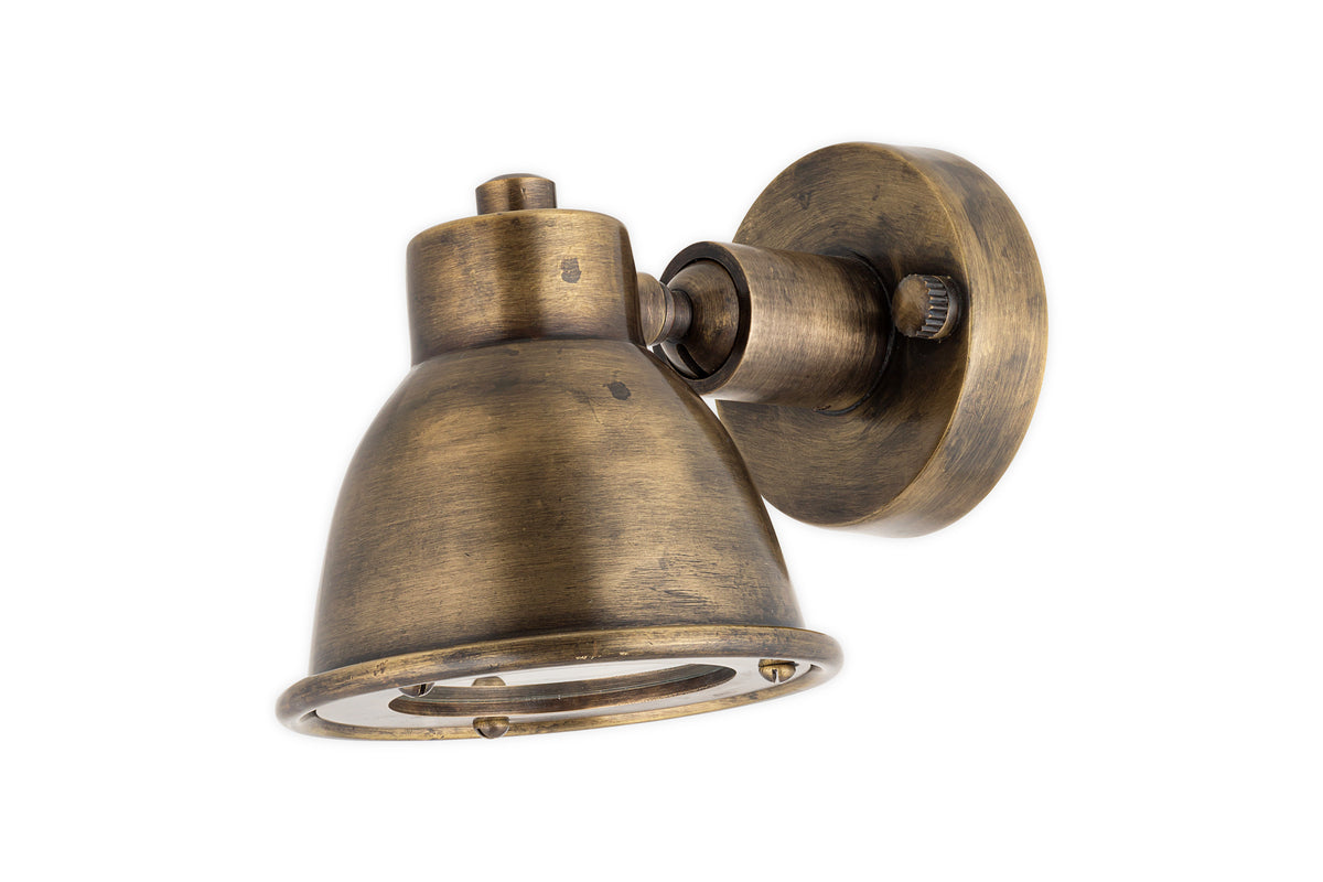The nkuku Kasai Brass Spotlight in Antique Brass features a vintage-style, cone-shaped adjustable shade and round base, evoking industrial design. Perfect for adding rustic charm to your space. Shown isolated on a white background.
