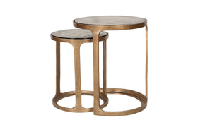 The Khidki Cast Metal & Glass Nesting Side Tables by nkuku feature two round tables with antique brass frames and glass tops, adding elegance to any space.