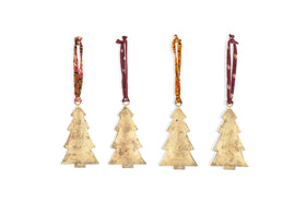 Four Mishti Tree Baubles in antique brass by nkuku are displayed in a row, each iron ornament hanging from a unique ribbon. The set of four features a rustic, weathered finish and stands out against a plain white background.