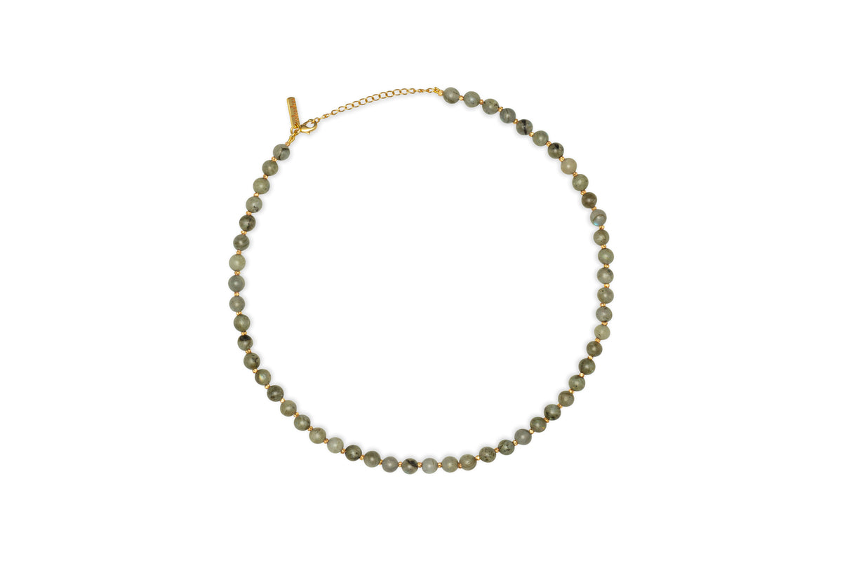 The nkuku Marai Necklace - Labradortite features a single strand of round, gray-green labradorite beads with a gold chain and adjustable clasp, displayed on a white background—an elegant accessory for any occasion.