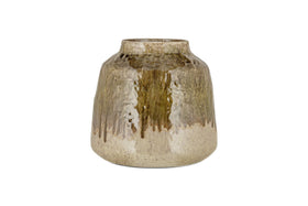 The Melina Reactive Glaze Vase by nkuku features a wide body, narrow opening, and glossy finish. Its olive and natural tones blend in organic dripped patterns, giving it a rustic charm. Displayed against a plain white background.
