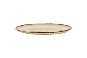 The nkuku Malia Large Oval Platter in cream features an organic shape, beige and brown reactive glaze, and a subtle ribbed rim texture, shown on a plain white background.