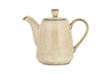 The Malia Teapot - Cream by nkuku features a curved spout, rounded handle, and matching lid, crafted from cream-glazed stoneware and shown against a white background.