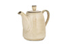 The nkuku Malia Teapot - Cream is a beige, cream-glazed stoneware piece featuring a round lid, curved spout and handle, with a subtle ribbed texture near the base that enhances its elegant design. Set against a plain white background.