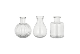 The nkuku Mayumi Recycled Glass Bud Vases - Clear (Set of 3) features three uniquely shaped clear vases, perfect for showcasing your favorite stems as elegant bud vases.