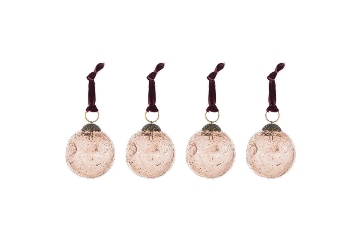 The nkuku Nishan Pinched Baubles - Copper (Set of 4) features four round, recycled glass baubles with a speckled vintage finish and burgundy velvet ties—perfect festive decorations for your holiday home.