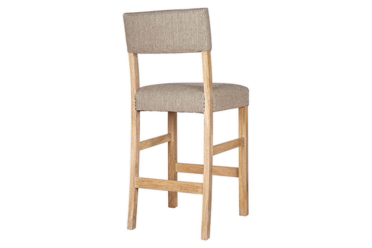 The nkuku Nadeeka Linen Upholstered Counter Chair in Soft Grey features cushioned linen seat and backrest, straight wooden legs, and a footrest—shown angled on a white background. Ideal for your kitchen island.