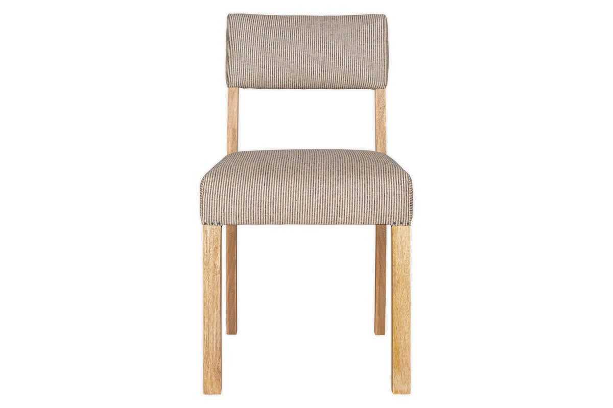 The Nadeeka Linen Upholstered Dining Chair by nkuku features a mango wood frame and soft grey linen cushioned seat and backrest, viewed from the front to highlight its simple, minimalist design.