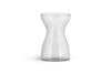 The Enir Hyacinth Vase - Clear by nkuku features clear hammered glass with a textured, dimpled surface and a narrow neck that curves to wide openings. The empty vase is shown against a plain white background.