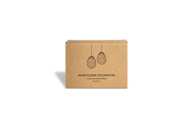 A small brown nkuku box with black line drawings of two hanging decorations. Text below reads: Piani Mini Hanging Paper Decoration - Natural & Moss - Set of 12. The box is centered on a white background.