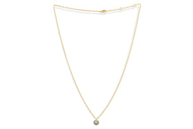 The Marai Labradorite Necklace by nkuku features a delicate gold chain with a round grayish-blue labradorite pendant. The fine, adjustable chain makes it a perfect jewelry gift, shown on a white background.