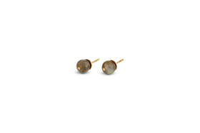 The Marai Labradorite Stud Earrings by nkuku feature round, gray labradorite stones set in sleek gold bezels with straight post backings—an elegant minimalist choice for jewelry lovers.