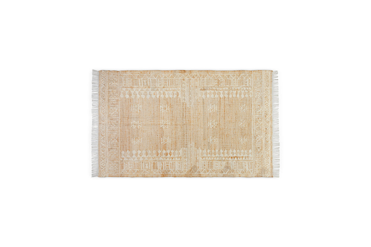 The nkuku Aqil Jute & Cotton Rug - Natural is a rectangular beige rug with white and tan geometric patterns, symmetrical borders, and short white fringe on the shorter edges, shown on a plain white background.