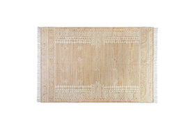 The nkuku Aqil Jute & Cotton Rug - Natural is a rectangular beige rug inspired by traditional Indian design, featuring white geometric tribal patterns and fringed edges, displayed on a plain white background.