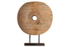 The Cala Reclaimed Wood Objet on Stand - Natural by nkuku features a round, flat wooden disk with a central hole, displayed upright on a simple black metal stand. Visible grain and cracks highlight its rustic charm against a plain white background.