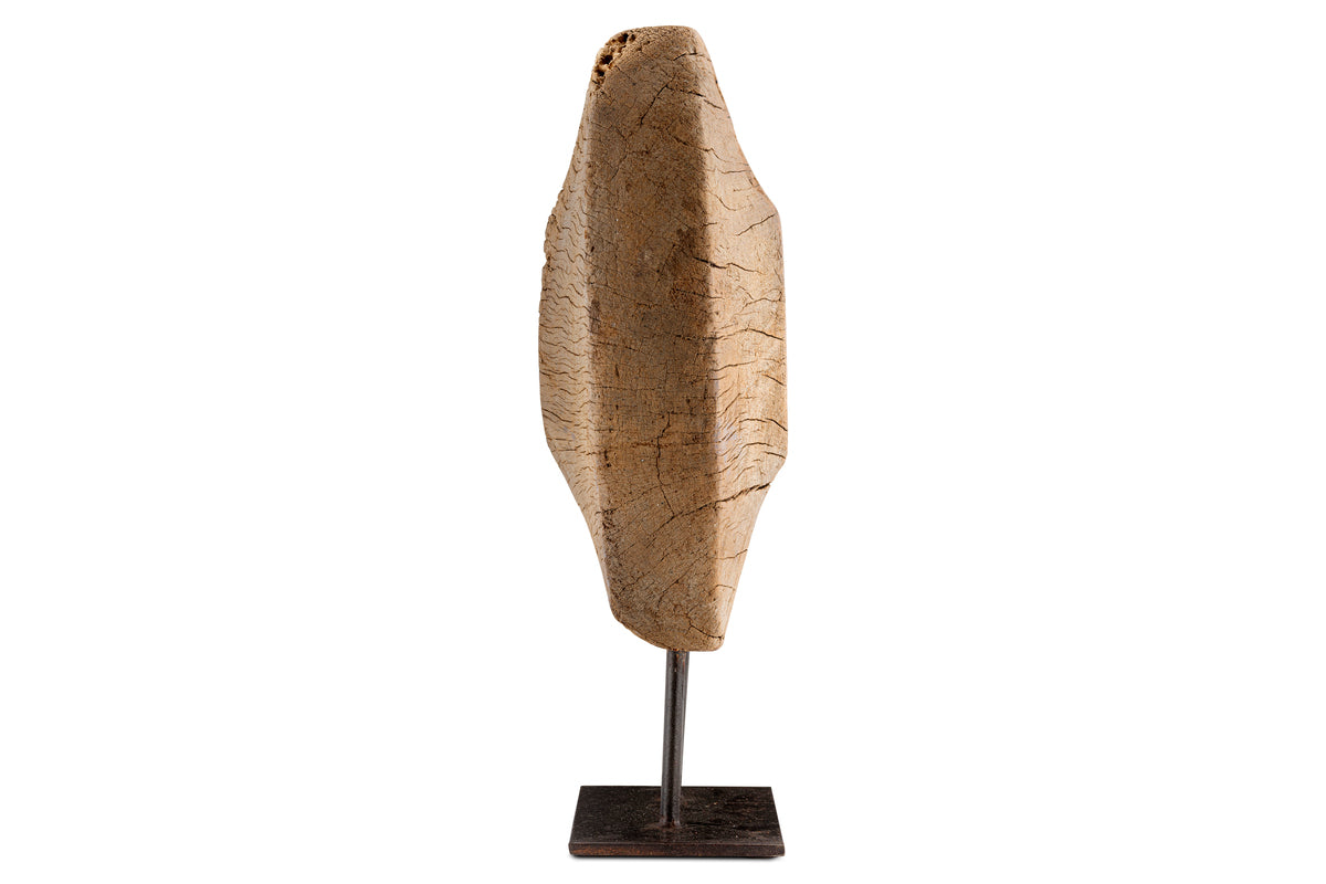 The Cala Reclaimed Wood Objet on Stand - Natural by nkuku is a vertical sculpture crafted from light brown reclaimed wood with a rustic, textured finish. Mounted on a slim metal rod and black base, it adds organic elegance to your decor.