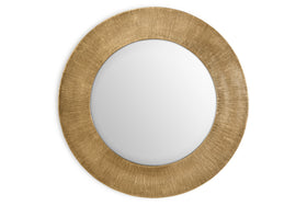 The nkuku Moto Round Mirror - Antique Brass features a wide, textured gold frame with fine lines for a subtle sunburst effect. Its minimalist design and antique brass finish add elegance and style to any space.